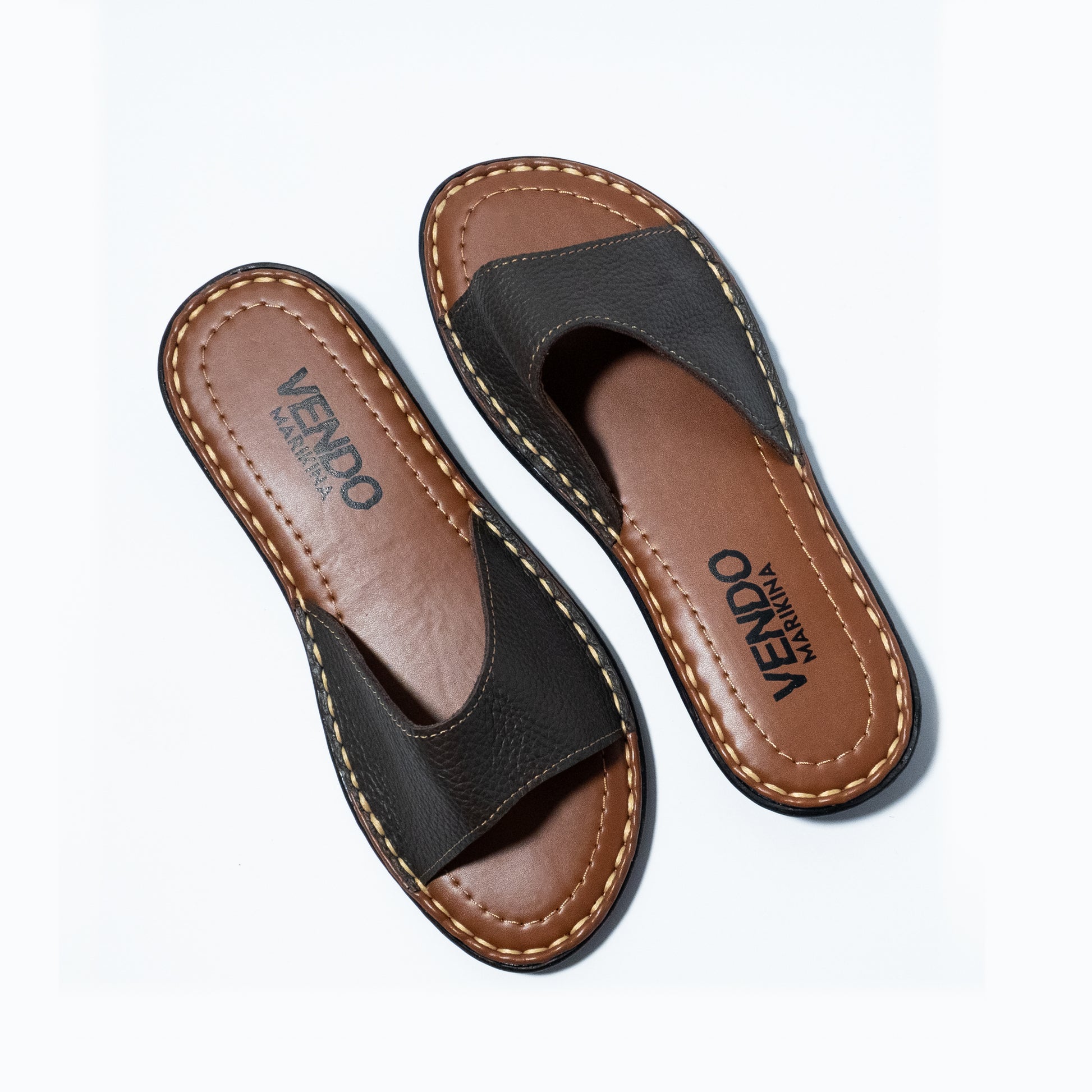 Pair of brown and black sandals with 'VENDO' branding on a white background
