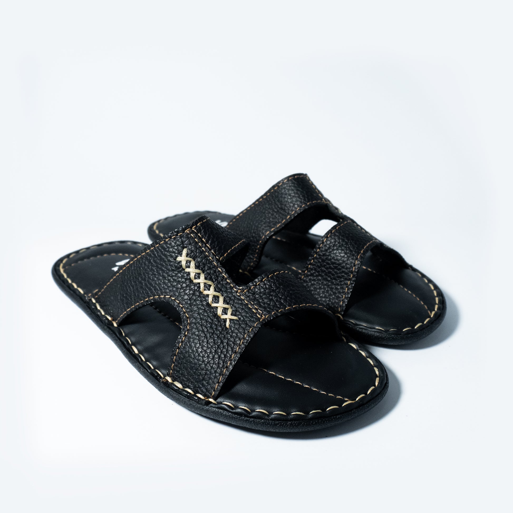 Black sandal with stitching design on a light gray background