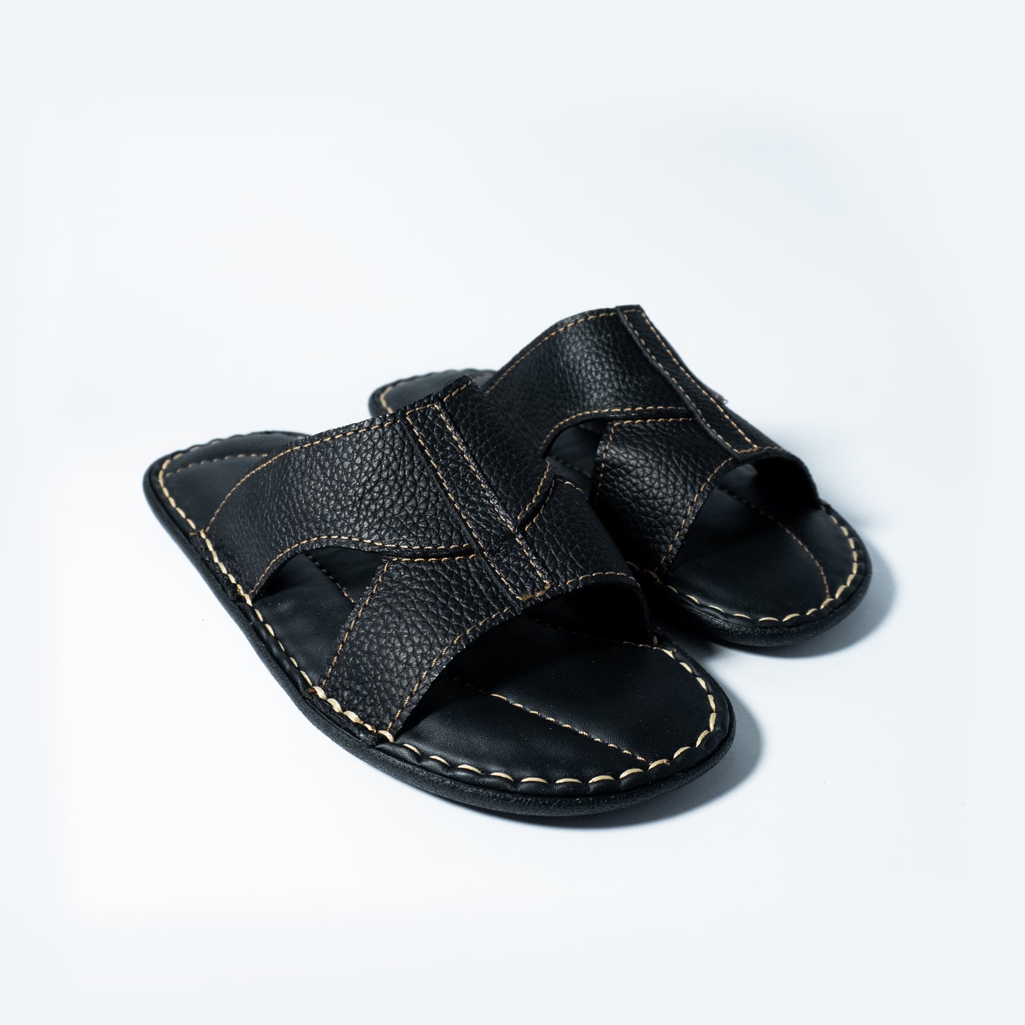 Black leather sandal on a light gray background