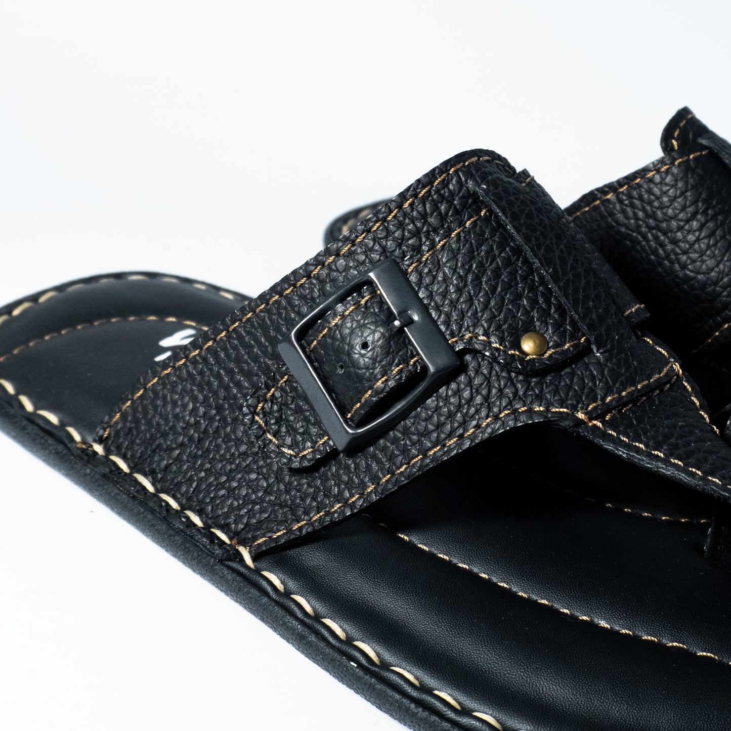 Close-up of a black sandal with a buckle on a white background