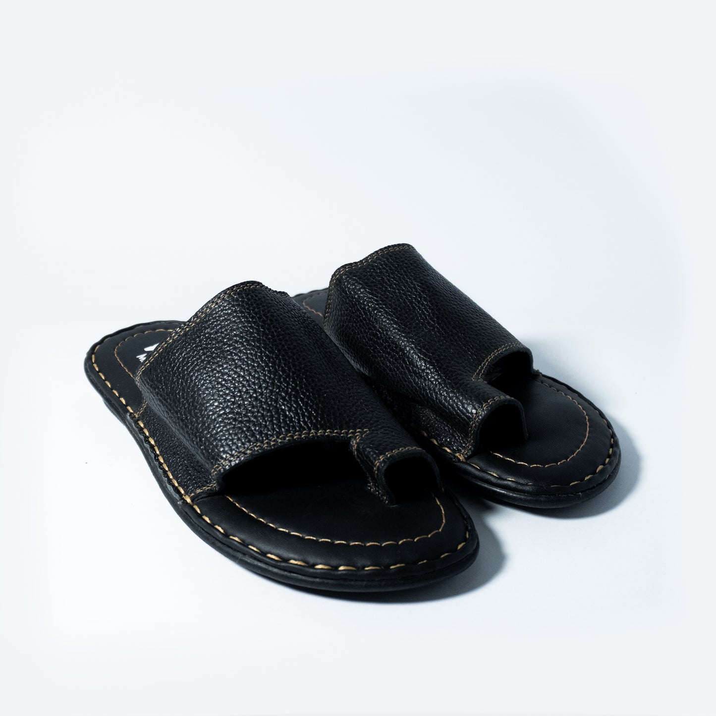Pair of black leather sandals on a light gray background