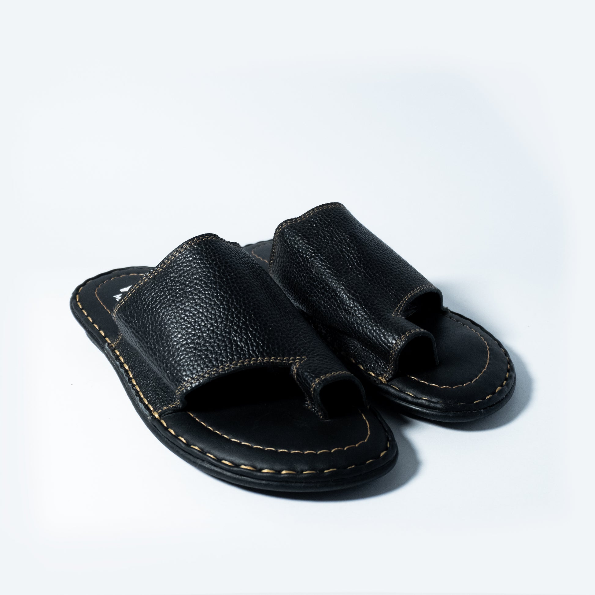 Pair of black leather sandals on a light gray background