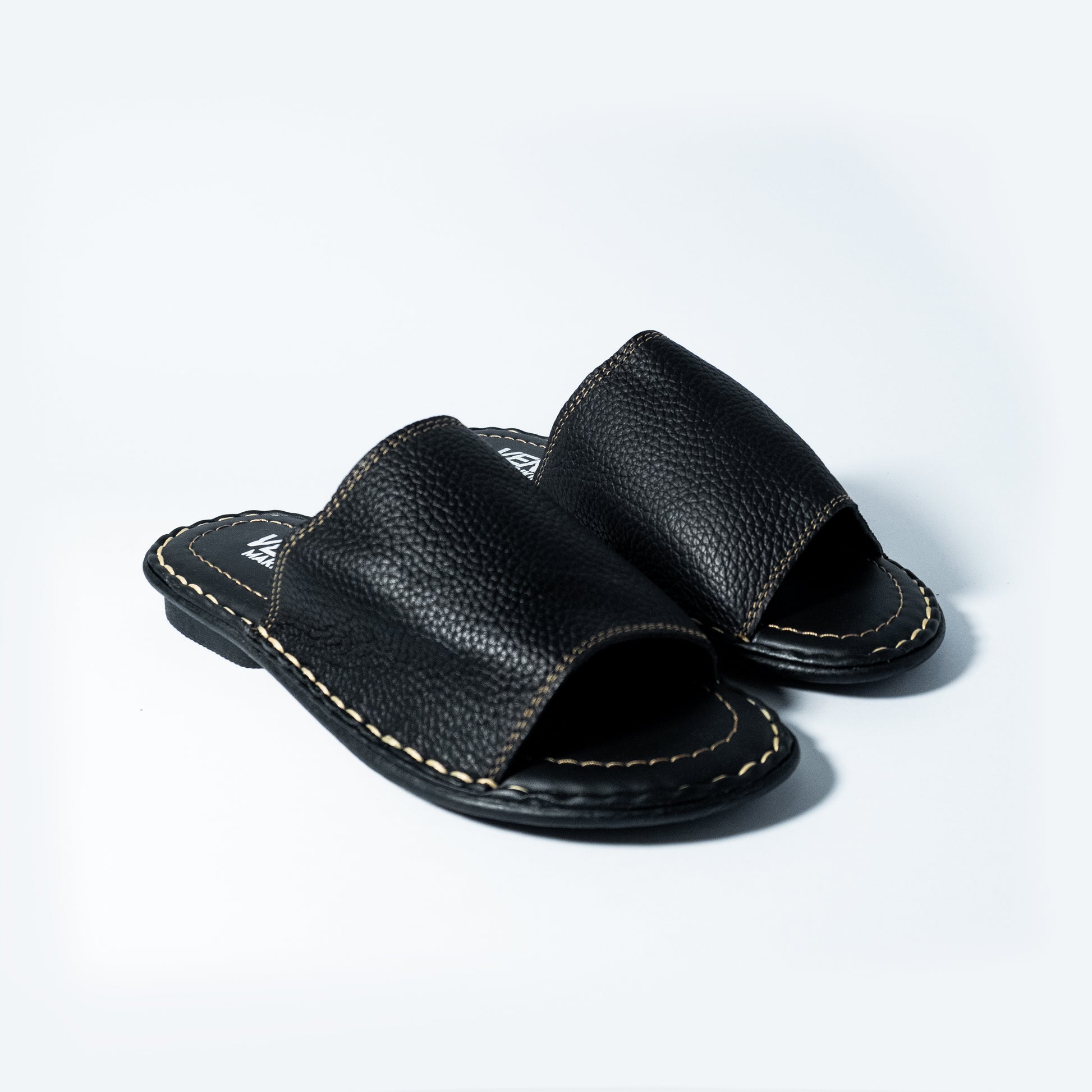 Pair of black leather sandals on a light gray background