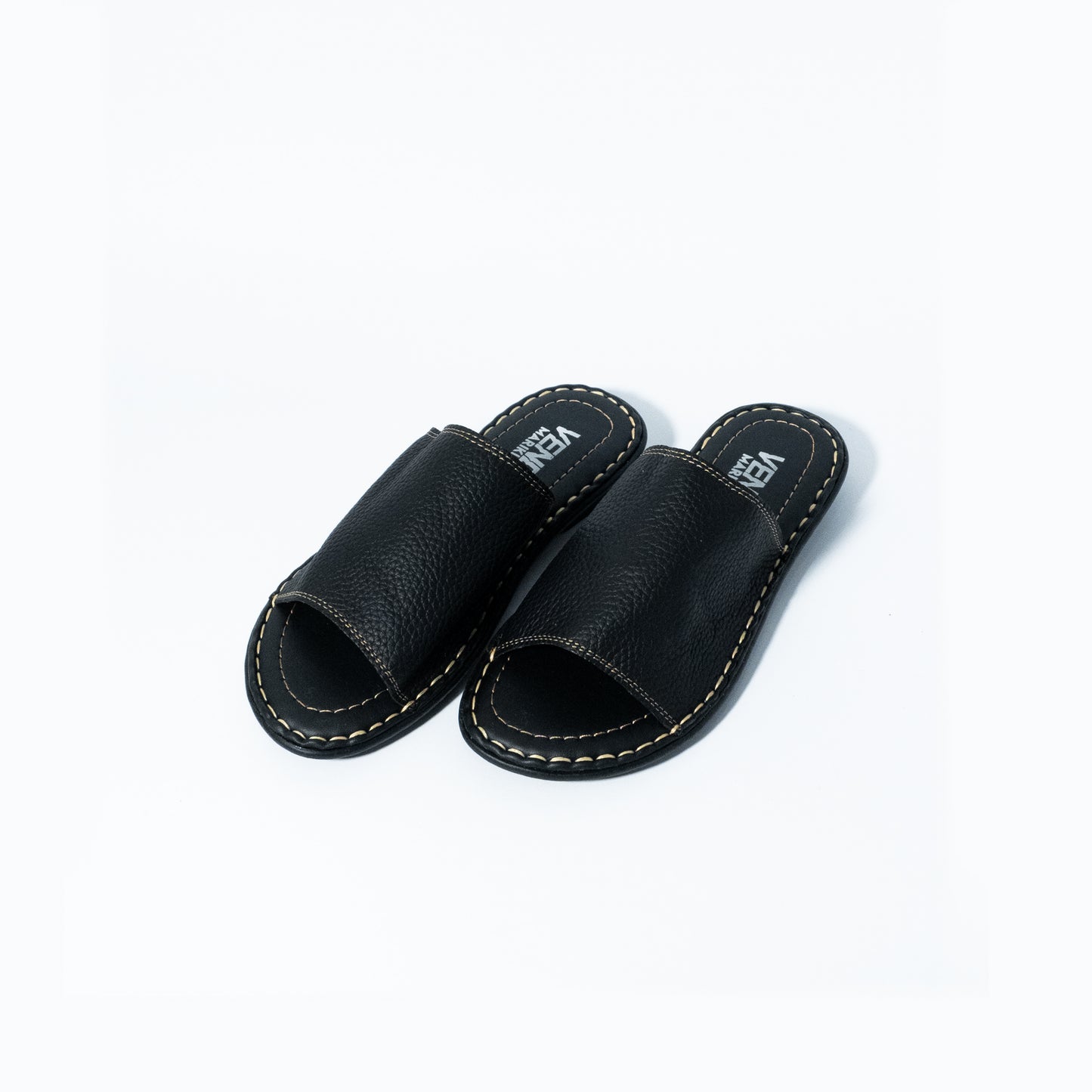 Pair of black leather slippers on a white background