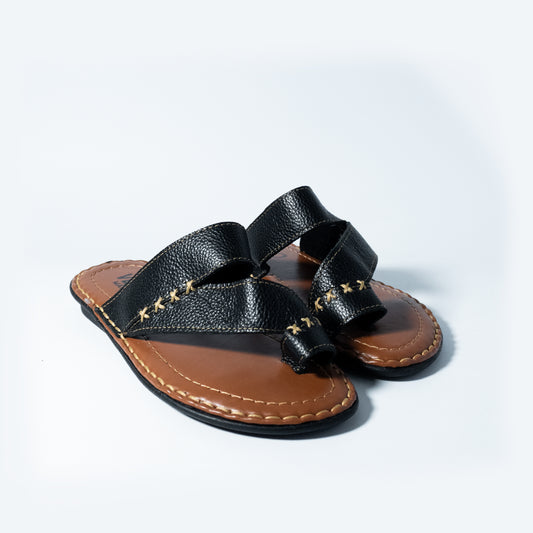 Black leather sandal with brown sole on a light gray background