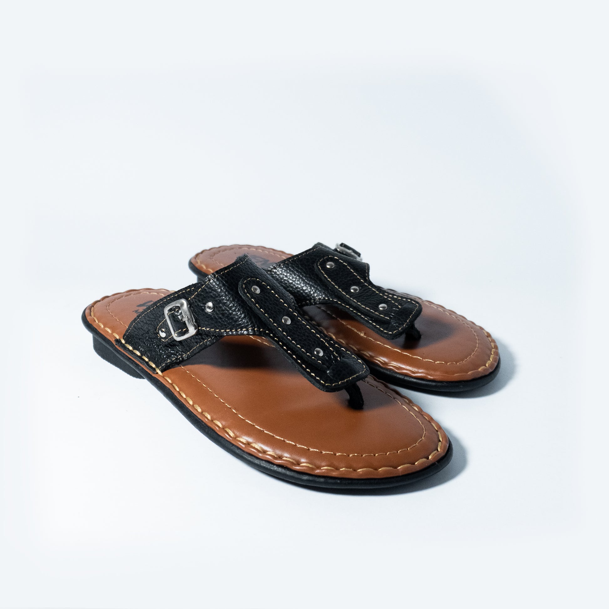 Pair of black and brown sandals on a light gray background