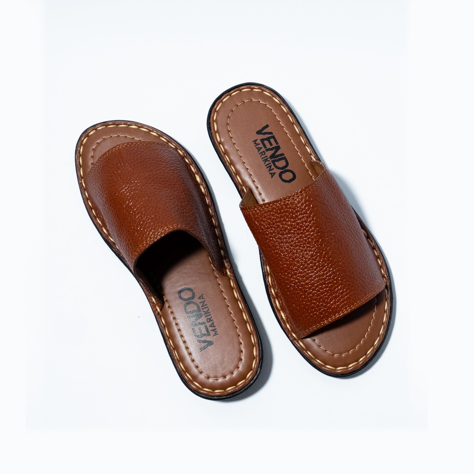 Pair of brown leather sandals with 'VENDO' branding on a white background