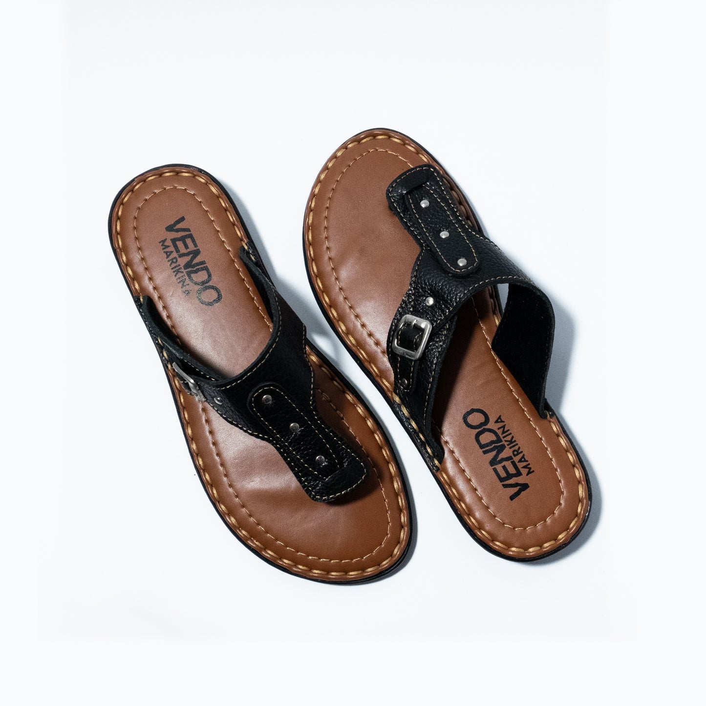 Pair of brown and black sandals with 'VENDO' branding on a white background