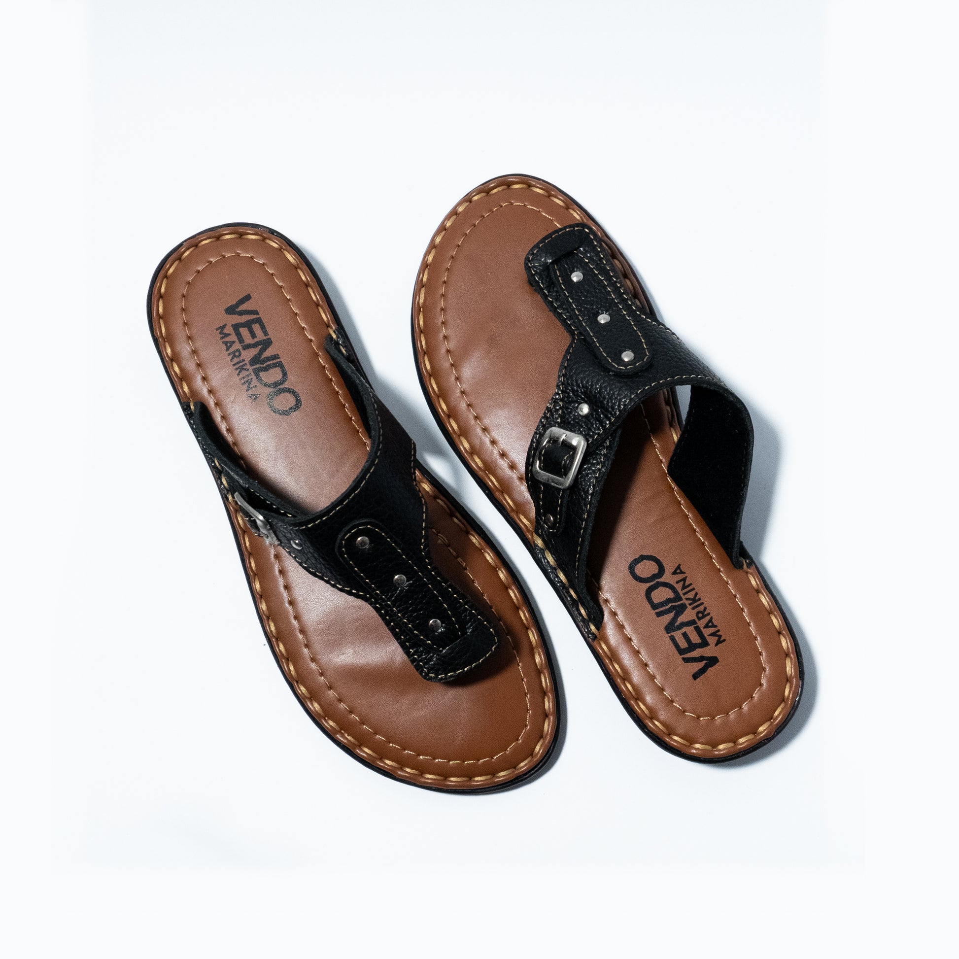 Pair of brown and black sandals with 'VENDO' branding on a white background