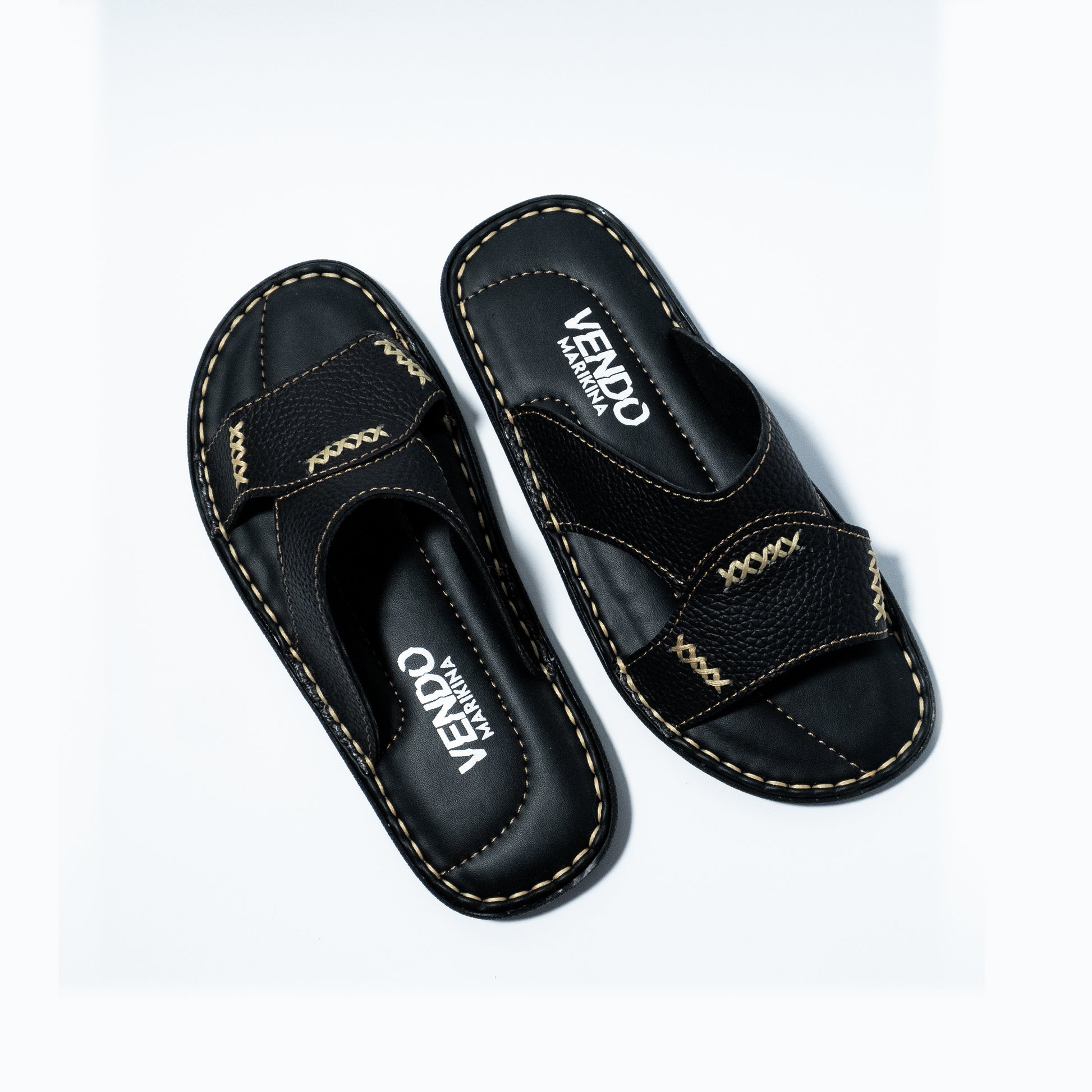 Black sandals with stitching design on a white background